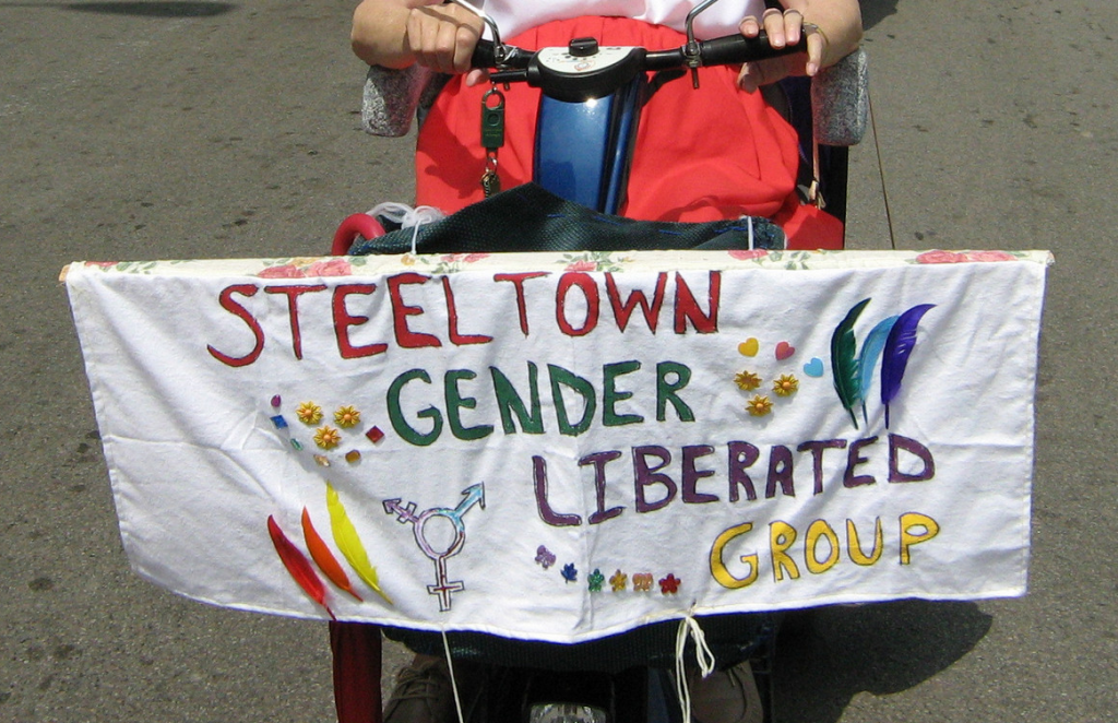 Steeltown Gender Liberated Group (a banner in a parade hung on a mobility device)